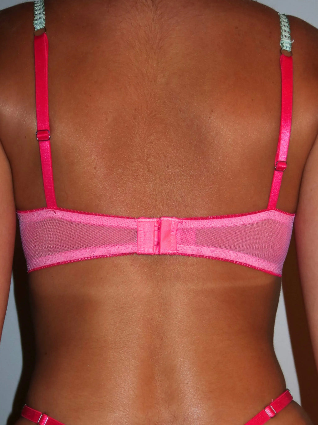 Pink lingerie bra on a plain background